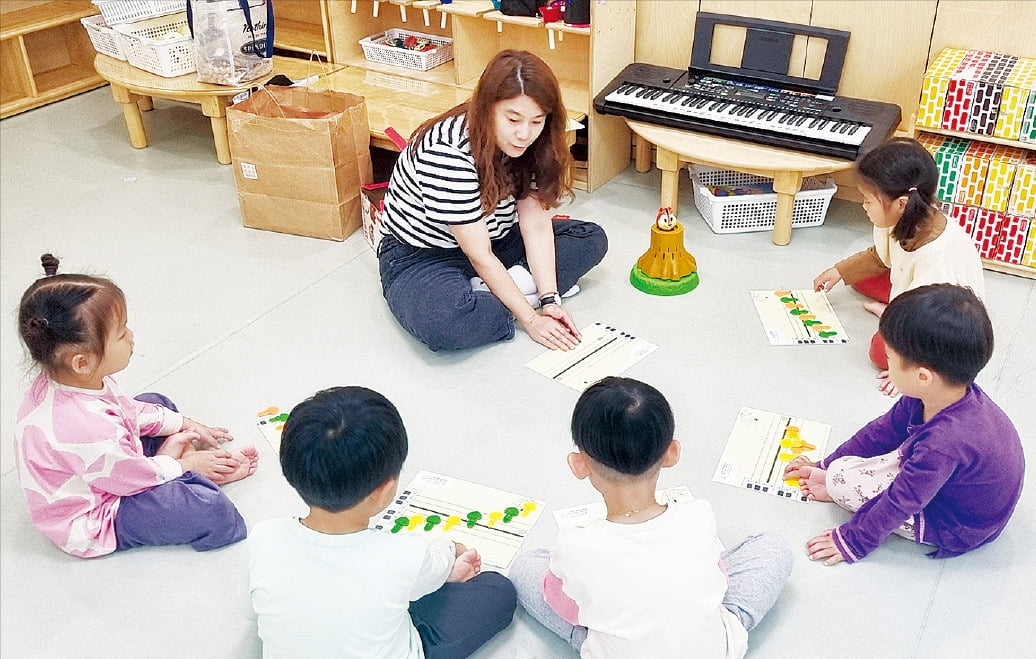 서울 잠실 롯데월드에 있는 ‘맘(mom)편한 어린이집’에서 어린이들이 지도 선생님의 설명을 듣고 있다. /롯데지주 제공 