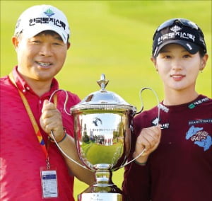 박현경(오른쪽)과 그의 아버지이자 캐디인 박세수 씨가 29일 우승컵을 함께 들어 올리고 있다. 
 KLPGA 제공 