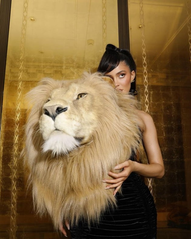 Youngest billionaire has a giant stuffed lion head on his shoulder