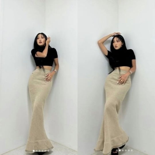 Hwasa takes a photo leaning against a wall, showing off her post-Asian pelvis