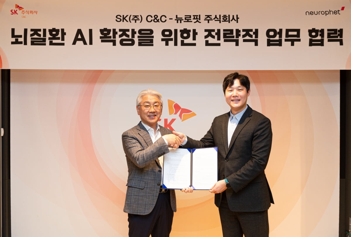 윤동준 SK C&C 헬스케어그룹장(왼쪽)과 빈준길 뉴로핏 대표가 23일 경기 성남 분당구 SK u-타워에서 업무협약을 맺고 기념촬영하고 있다. 사진제공=SK C&C