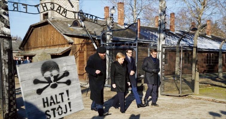 앙겔라 메르켈 독일 총리(왼쪽에서 2번째)가 2019년 12월 폴란드 아우슈비츠 나치 강제 수용소를 찾은 모습. 정문 위에는 “노동이 너희를 자유케 하리라”라는 구호가 걸려 있다. 로이터 연합뉴스 