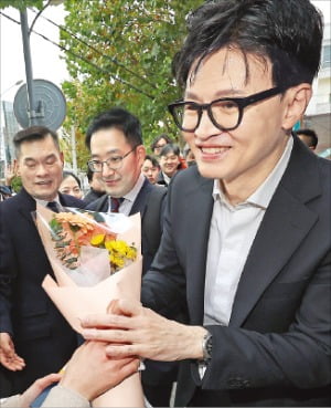 한동훈 법무부 장관이 지난 17일 대구 만촌동 스마일센터 방문 중 한 시민으로부터 꽃다발을 받고 있다.  연합뉴스 