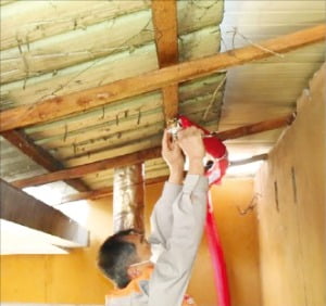 화재보험협회 직원이 산림 인접지역 주택 보일러실에 간이스프링클러를 설치하고 있다. /화재보험협회 제공 