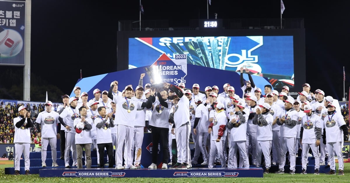 LG트윈스 구단주인 구광모 LG그룹 회장(앞줄 왼쪽 셋째)이 13일 서울 잠실구장에서 열린 2023 신한은행 SOL KBO리그 한국시리즈 5차전에서 LG 트윈스의 우승이 확정된 이후 선수들과 우승 트로피를 들어올리며 기뻐하고 있다.    사진=연합뉴스