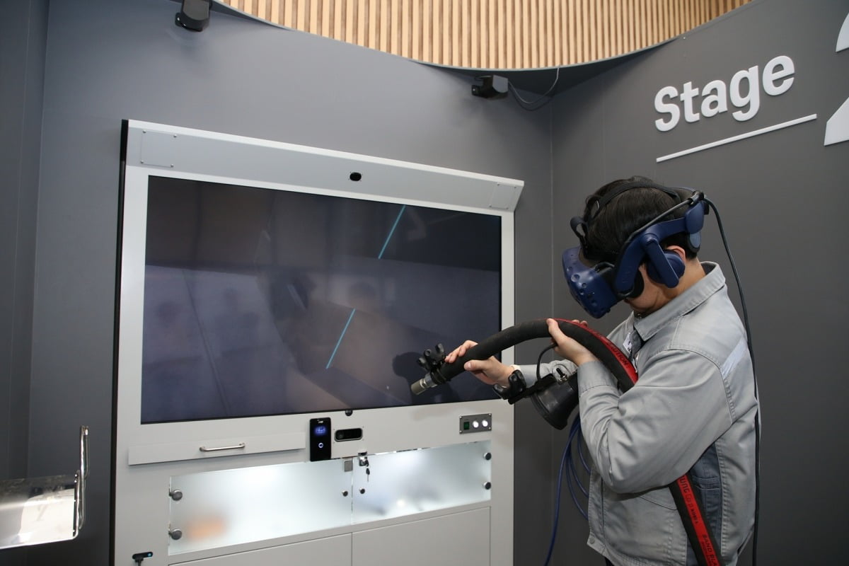 한화오션 거제사업장 내부에 위치한 VR 도장교육센터에서 새롭게 개발된 'RealBLAST'를 통해 VR 블라스팅 직무훈련이 진행되고 있다. 사진=한화오션
