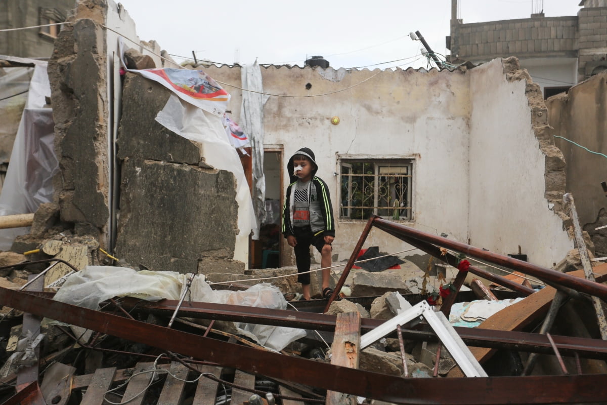15일(현지시간) 가자지구 라파에서 한 소년이 무너진 건물의 잔해 위에 서 있다./사진=연합뉴스