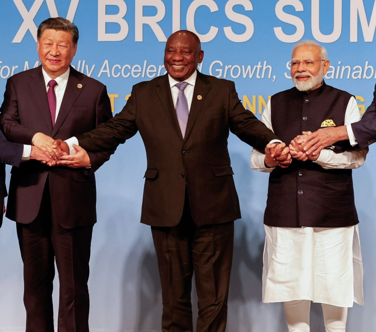 시진핑 중국 국가주석(왼쪽)과 나렌드라 모디 인도 총리(오른쪽)이 지난 8월 남아프리카공화국 요하네스버그에서 열린 브릭스 정상회의에서 시릴 라마포사 남아공 대통령과 함께 손잡고 있다.  /AFP