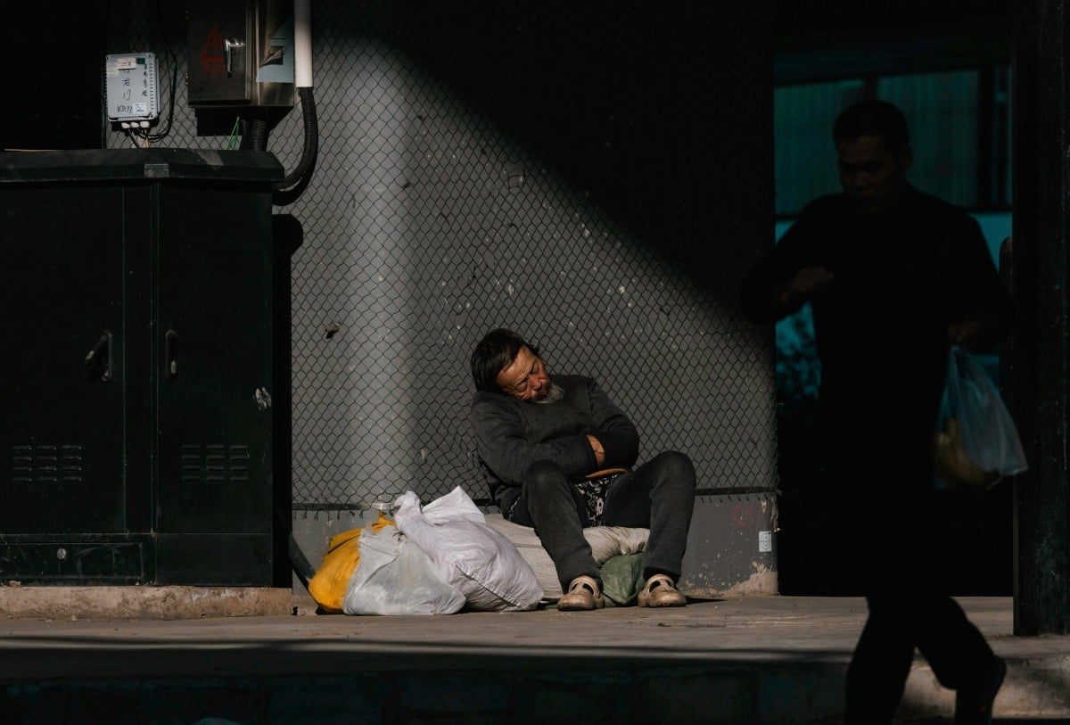 지난달 29일(현지시간) 중국 상하이에서 한 남성이 다리 아래에서 햇볕을 쬐며 낮잠을 자고 있다.  /EPA