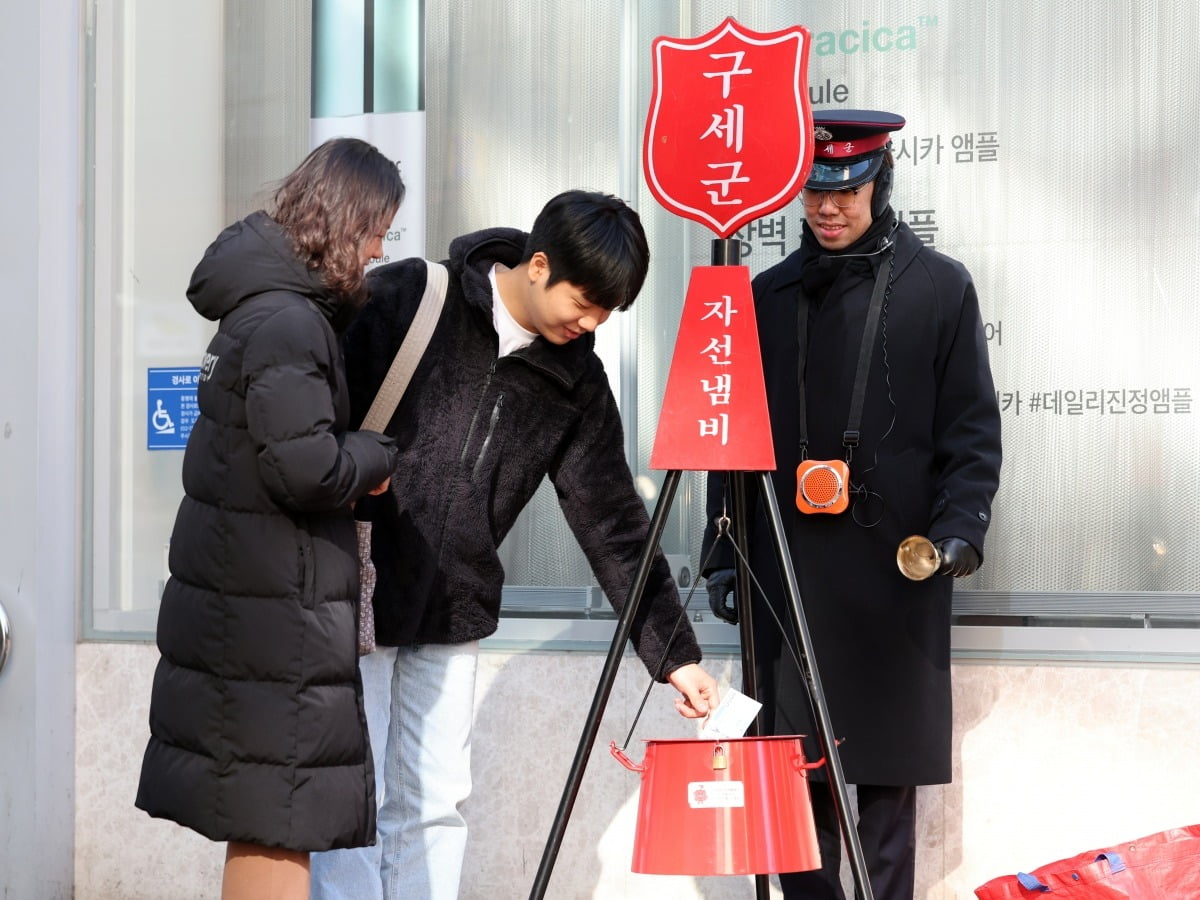 1일 오후 시민들이 서울 중구 명동에서 구세군 자선냄비에 성금을 넣고 있다./사진=최혁 기자
