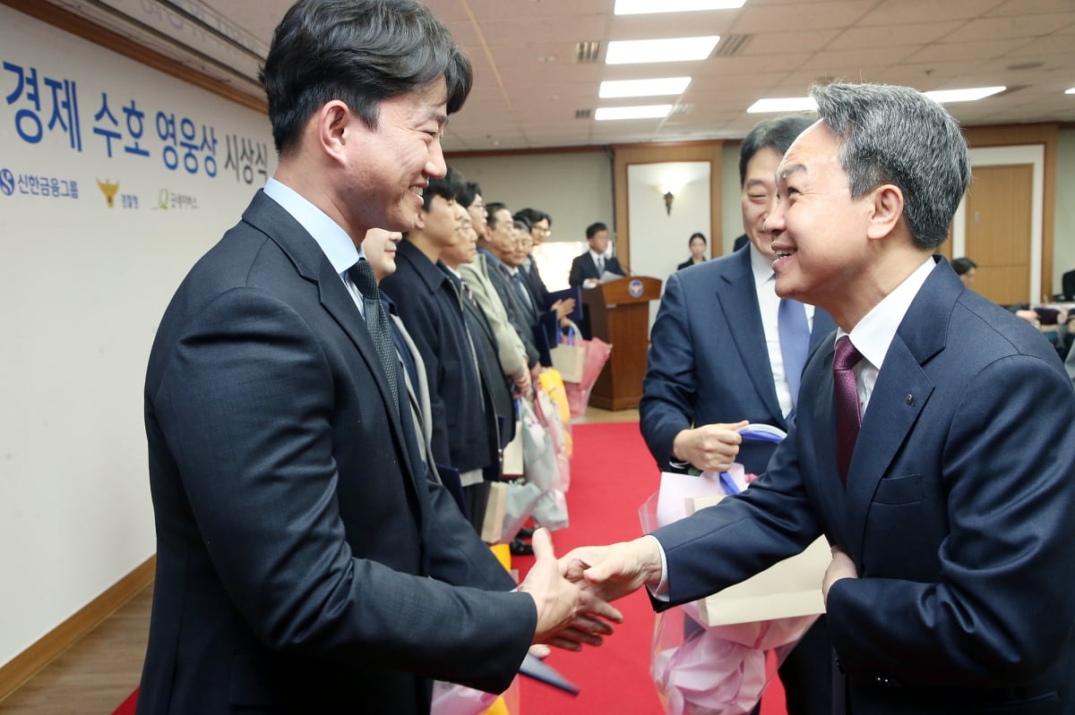 진옥동 신한금융그룹 회장이 서울 미근동 경찰청에서 열린 '서민경제 수호 영웅상 시상식'에서 강상우 경위(왼쪽)를 포함한 10명의 수호 영웅들에게 축하 및 감사 인사를 전하고 있다. 신한금융그룹 제공