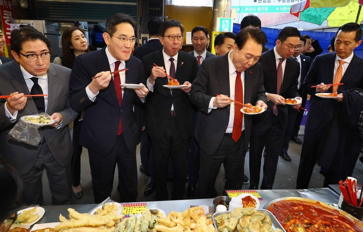 윤석열 대통령과 재계 총수들이 6일 부산 중구 깡통시장을 방문해 떡볶이를 시식하고 있다.  /부산=김범준 기자