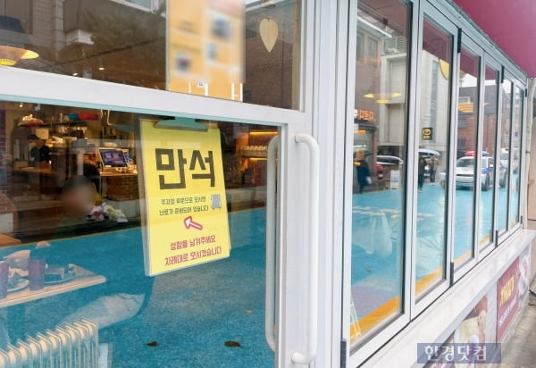 비가 오는 날씨에도 사람이 몰린 한 맛집 앞에 '만석' 안내문이 붙은 모습. /사진=김세린 기자