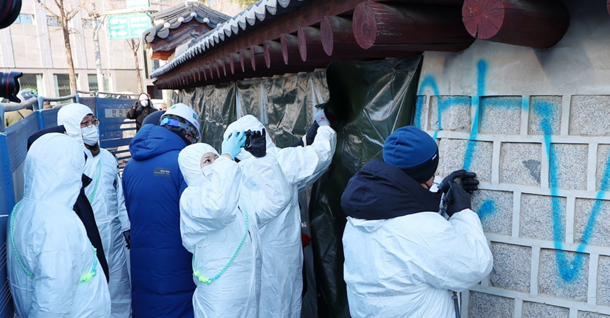  17일 오전 서울 종로구 국립고궁박물관 쪽문 경복궁 담벼락에서 문화재청 관계자들이 전날 누군가가 스프레이로 쓴 낙서 제거 작업을 하고 있다.  /사진=연합뉴스