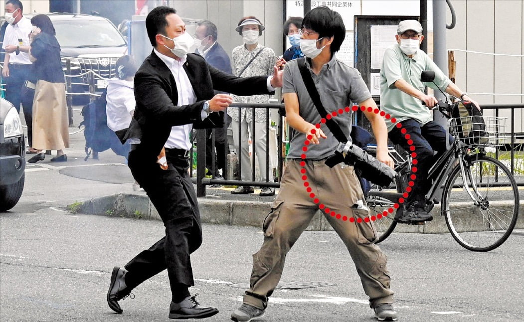 8일 일본 나라시 야마토사이다이지역 인근에서 경찰이 아베 신조 전 일본 총리에게 총을 쏜 용의자 야마가미 데쓰야(41)를 제압하고 있다. 빨간 원 안에 용의자가 개조한 총이 보인다. 게티이미지