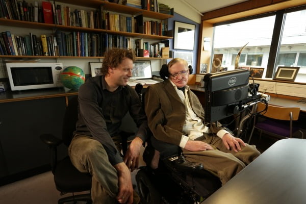 영국 케임브리지 수리과학과 캠퍼스 연구실에서 대화를 나누는 스티븐 호킹(오른쪽)과 저자 토마스 헤르토흐. 벽장에는 호킹의 제자들이 집필한 박사학위 논문이 빼곡히 꽂혀 있다. /RHK 제공