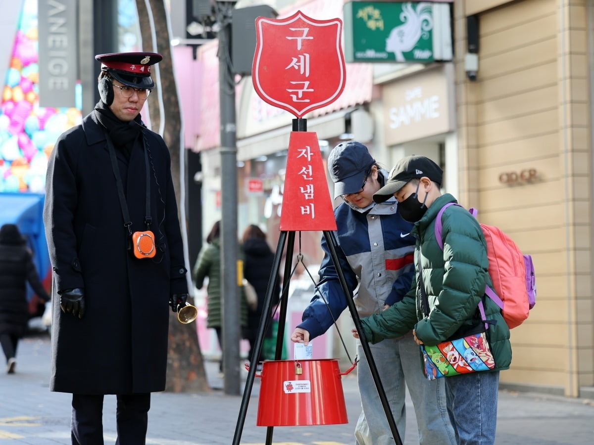 어린이들이 서울 중구 명동에서 구세군 자선냄비에 성금을 넣고 있다./최혁 기자