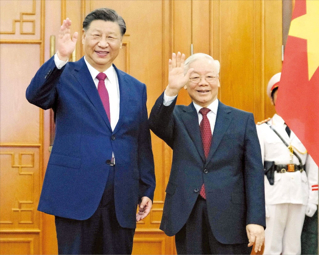< 손 흔드는 시 주석과 쫑 서기장 > 베트남을 국빈 방문한 시진핑 중국 국가주석(왼쪽)이 12일 베트남 하노이에서 베트남 권력 서열 1위인 응우옌푸쫑 공산당 서기장과 회담에 앞서 손을 흔들고 있다. 시 주석은 이날부터 1박2일 일정으로 베트남을 방문해 응우옌푸쫑 서기장, 보반트엉 국가주석과 회담하고 팜민찐 총리도 만날 예정이다.  AFP연합뉴스 