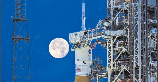 2022년 6월 미국 플로리다주 케이프커내버럴 케네디우주센터 발사대에 있는 아르테미스1호 로켓 뒤로 보름달이 떠 있다.  AP연합뉴스 