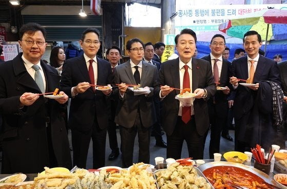 지난 6일 부산 중구 깡통시장에서 윤석열 대통령과 재계 총수들이 떡볶이, 튀김을 먹고 있다. 이들 중 절반 이상은 안경을 착용했다. (오른쪽부터) 김동관 한화그룹 부회장, 구광모 LG그룹 회장, 윤 대통령, 조현준 효성그룹 회장, 이재용 삼성전자 회장, 최재원 SK수석부회장(연합뉴스)