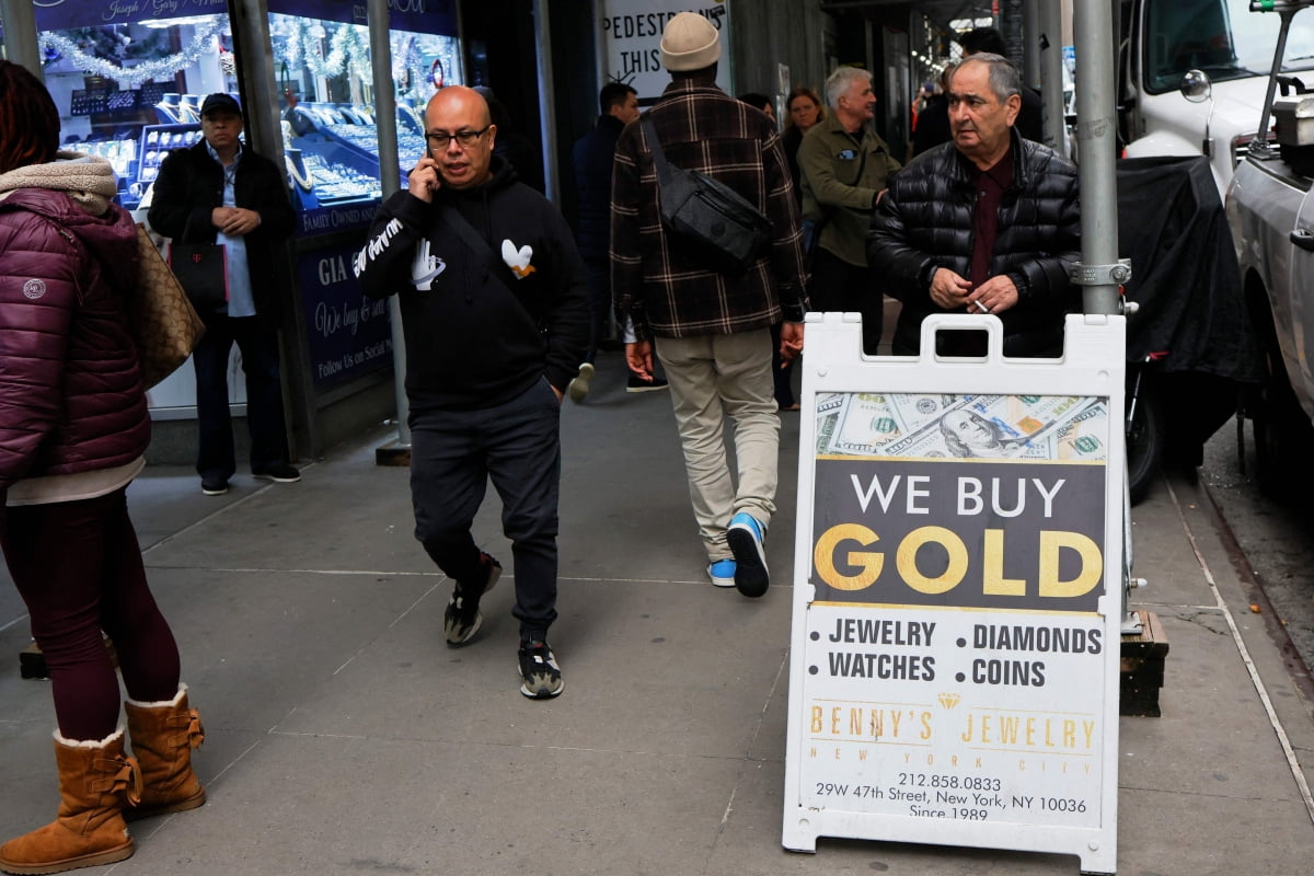 금 가격이 지난 2023년 12월 3일 트로이온스당 2100달러를 넘어서며 사상 최고가를 기록했다. 사진은 2023년 12월 4일 뉴욕 다이아몬드 거리에서 한 남성이 금 매입을 광고하고 있다.  /AFP연합뉴스