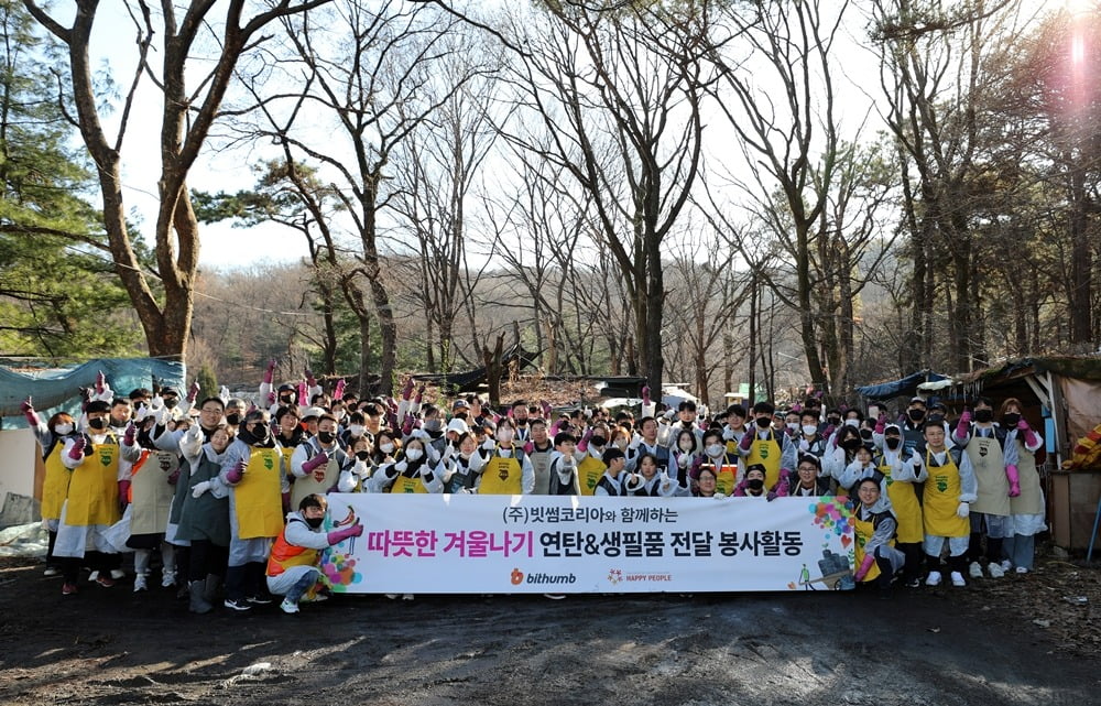 지난 6일 오전 서울 개포동 구룡마을에서 빗썸 임직원들과 가족들이 연탄 나눔 봉사활동을 마치고 기념사진 촬영을 하고 있다. / 사진=빗썸