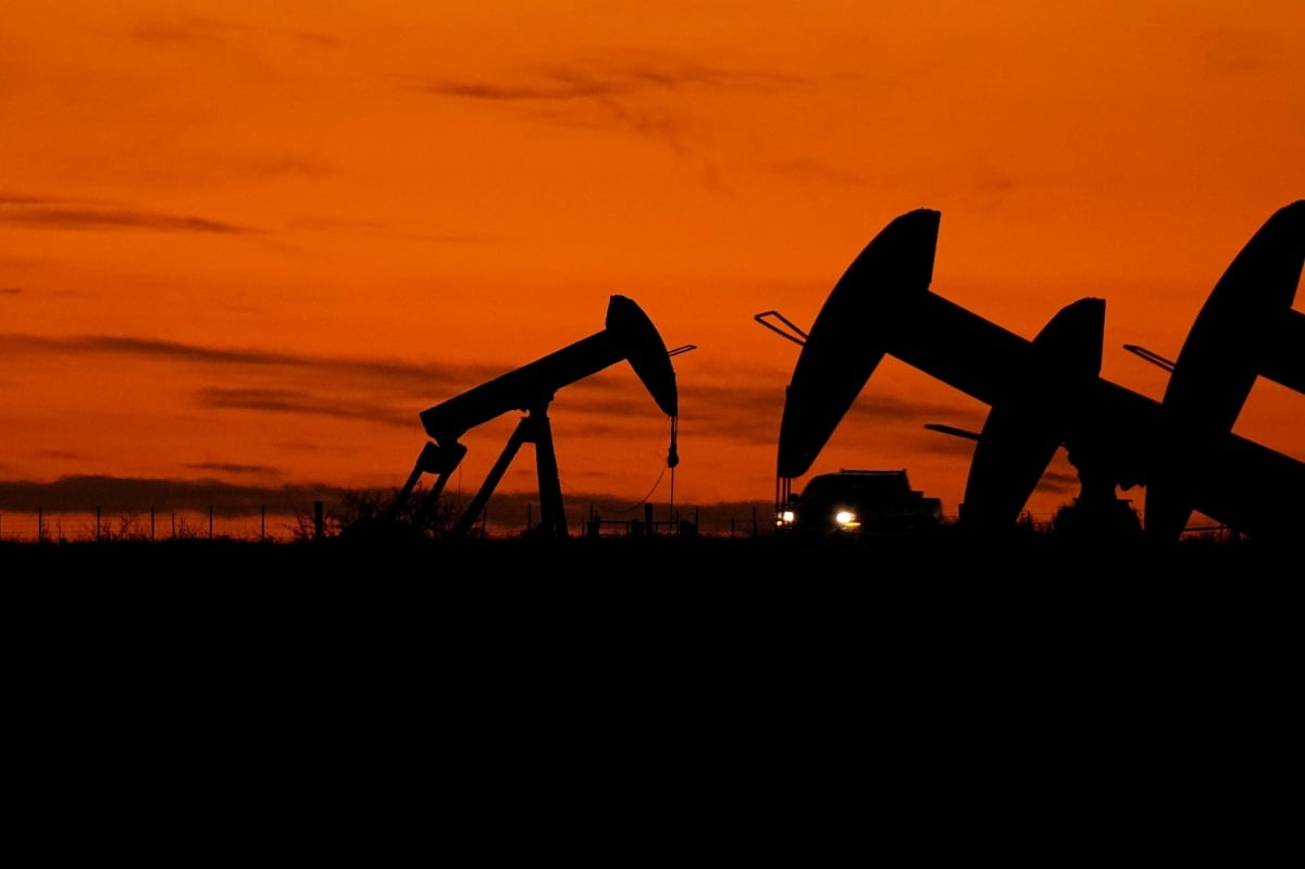 지난해 11월 미국 텍사스주 카네스시에서 트럭 한 대가 석유 펌프 잭을 지나가고 있다. AP