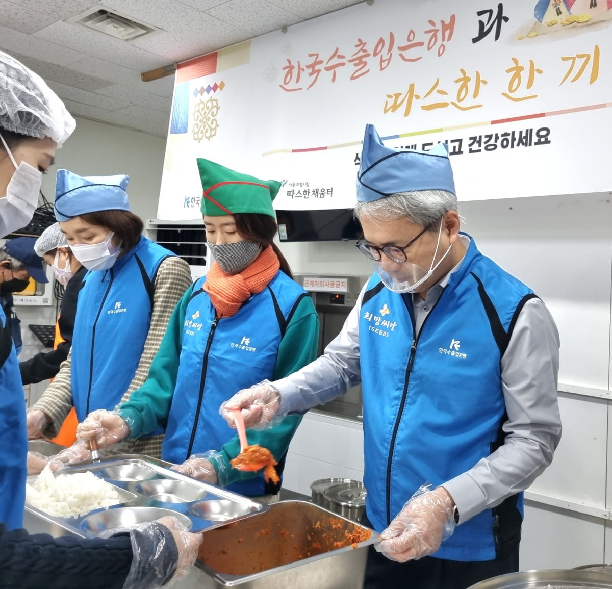 한국수출입은행이 설을 맞아 전국 17개 사회복지시설에 총 1억8000만원을 기부했다. 윤희성 수은 행장(오른쪽)과 임직원들이 노숙인 대상 무료 급식소 따스한 채움터에서 배식 봉사를 하고 있다. 수출입은행 제공