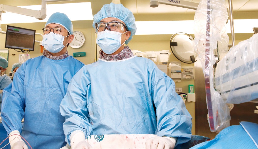 박덕우 서울아산병원 심장내과 교수(오른쪽)가 경피적 대동맥 판막 치환술(TAVI) 시술을 하고 있다.  서울아산병원 제공 