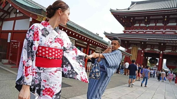 도쿄 아사쿠사에서 일본 전통의상 유카타를 입고 사진촬영 중인 외국인 관광객/사진=니케이 아시아