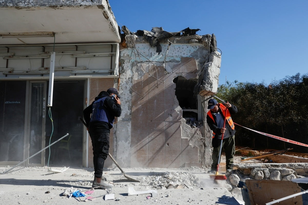 지난달 16일(현지시간) 이스라엘 네티보드에서 노동자들이 팔레스타인 무장정파 하마스의 로켓 공격으로 파손된 건물의 잔해를 치우고 있다. 로이터통신