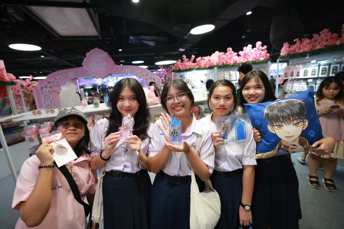 지난달 18~31일 태국 방콕 MBK센터에서 열린 네이버웹툰의 팝업스토어 행사에 참석한 태국인들이 웹툰 굿즈를 들어보이고 있다 .네이버웹툰 제공