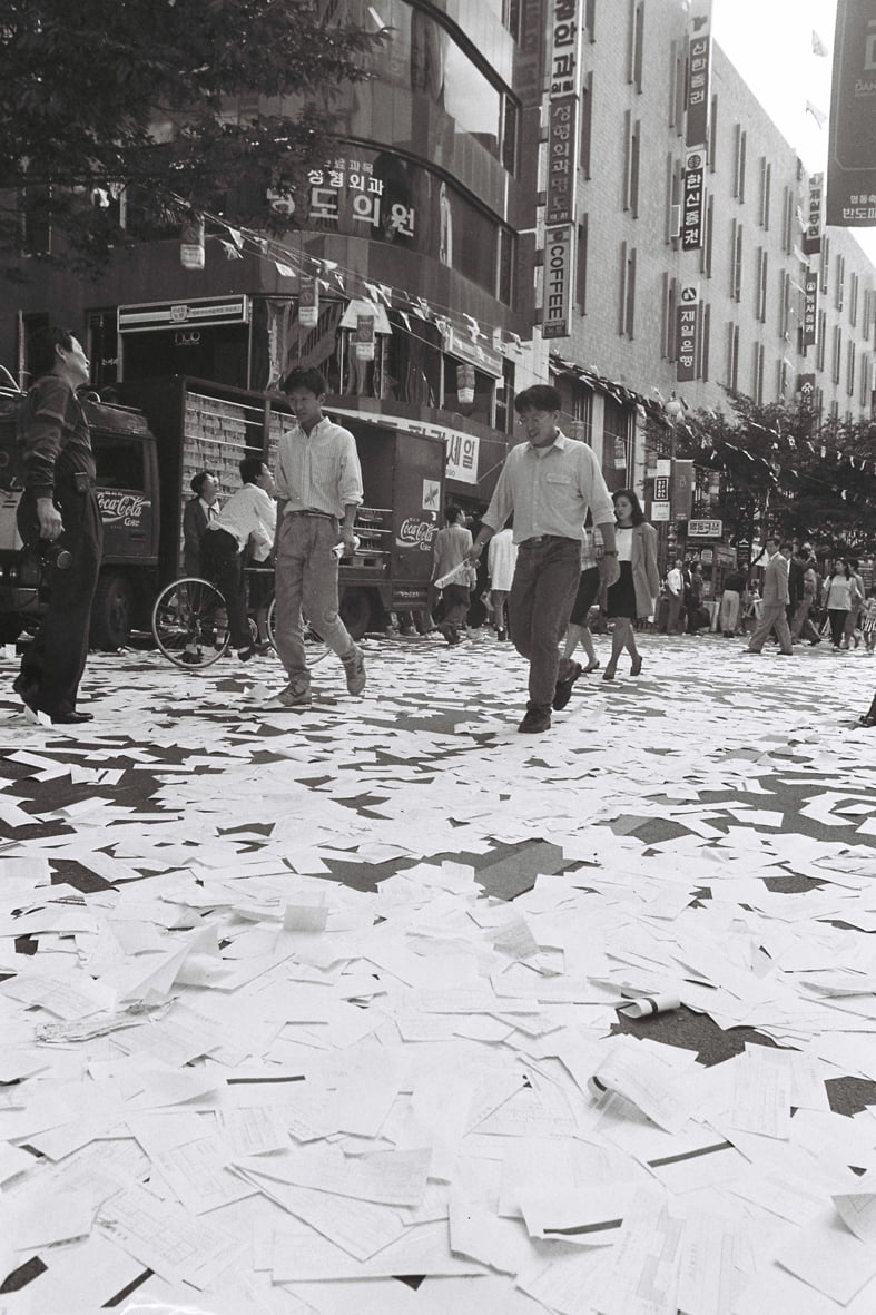 서울 명동에서 시민들이 1992년 9월 22일 거리에 뿌려진 주식매매전표를 밟고 지나가고 있다. 1992년 8월21일 투자자들이 주가 하락에 항의하는 뜻으로 명동거리에 전표를 뿌린데 이어 이날도 같은 시위가 벌어졌다. 