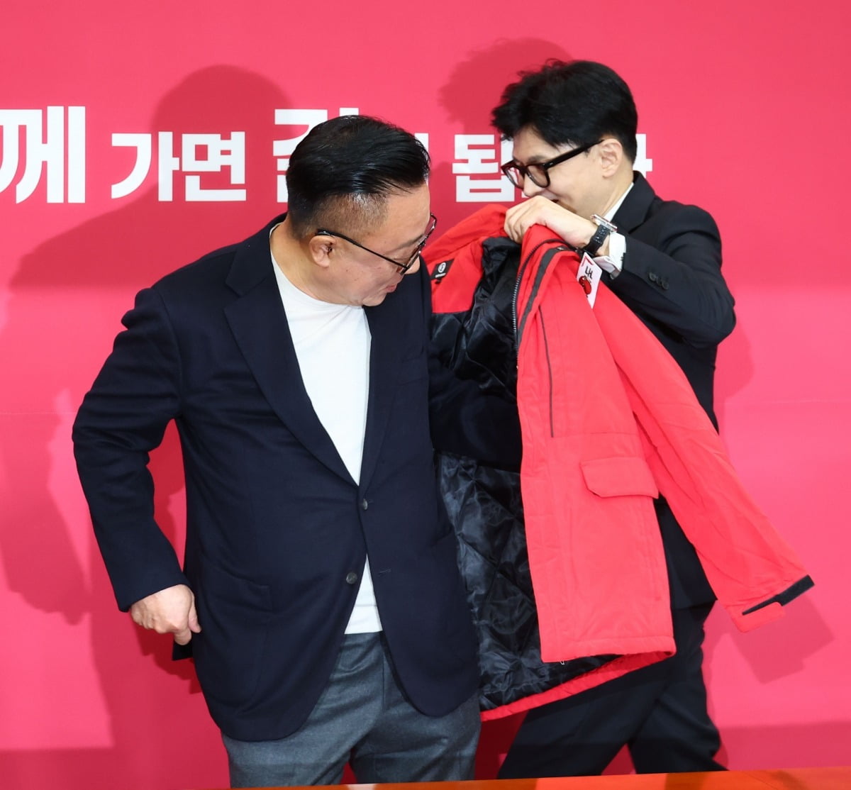 한동훈 국민의힘 비상대책위원장(오른쪽)이 고동진 전 삼성전자 사장에게 점퍼를 입혀주고 있다.연합뉴스