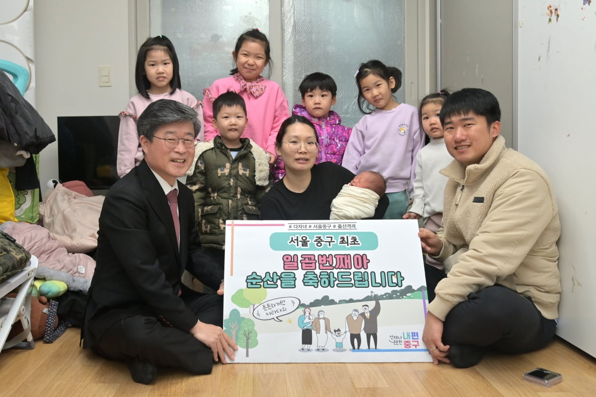 김길성 중구청장(왼쪽 아래)이 조용석 전혜희 부부의 일곱째 아이 시환군의 출산을 축하하는 양육지원금 1000만원을 전달하고 있다. /중구 제공