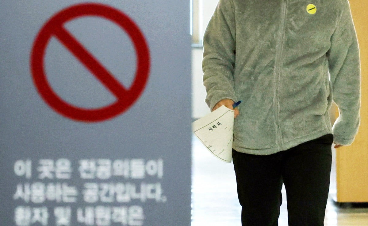 18일 서울의 한 대학병원 전공의 전용공간에서 한 전공의가 사직서를 들고 발걸음을 옮기고 있다./이솔 기자