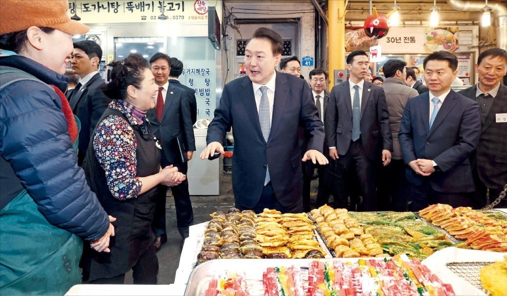 윤석열 대통령이 설 명절 연휴를 앞둔 8일 서울 중곡동 중곡제일시장을 찾아 상인들과 대화하고 있다. 윤 대통령은 이날 점포를 돌며 전, 한과, 떡 등 명절 음식을 구매했다. /김범준 기자 