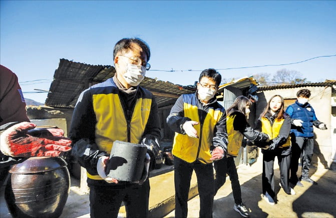 한국교통안전공단 권용복 이사장(맨 왼쪽)과 임직원이 사랑의 연탄 나눔 행사에서 연탄을 나르고 있다.  교통안전공단 제공 