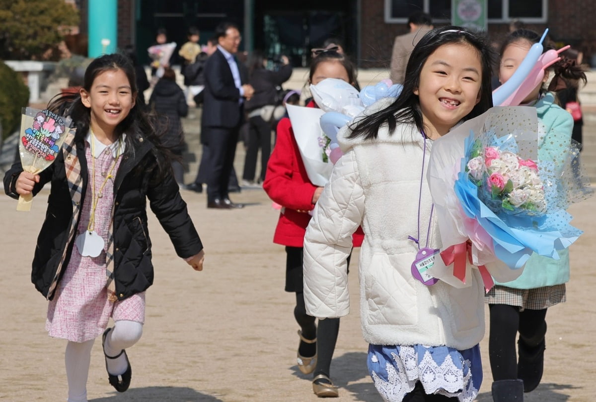 4일 서울 신정동 갈산초등학교에서 열린 입학식에서 1학년 어린이들이 친구와 인사하며 뛰어가고 있다. 