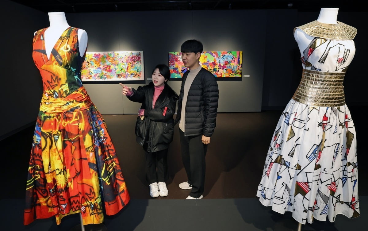 12일 서울 성북동 뮤지엄웨이브에서 개막한 그래피티 작가 시릴 콩고의 첫 개인전 '시릴 콩고의 메타 캔버스'를 찾은 관람객들이 샤넬과 협업한 드레스를 살펴보고 있다. 