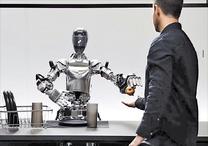 미국 인공지능(AI) 기업 오픈AI와 로봇 스타트업 피규어AI가 협력해 만든 휴머노이드 로봇이 사과를 집어 개발자에게 건네고 있다. /오픈AI 유튜브 영상 캡처