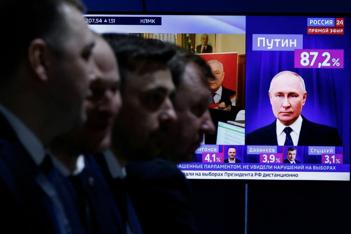 러시아 대통령 선거 마지막 날인 17일 모스크바에서 남성들이 개표 결과 뉴스를 중계하는 TV 옆에 앉아 있다. 로이터