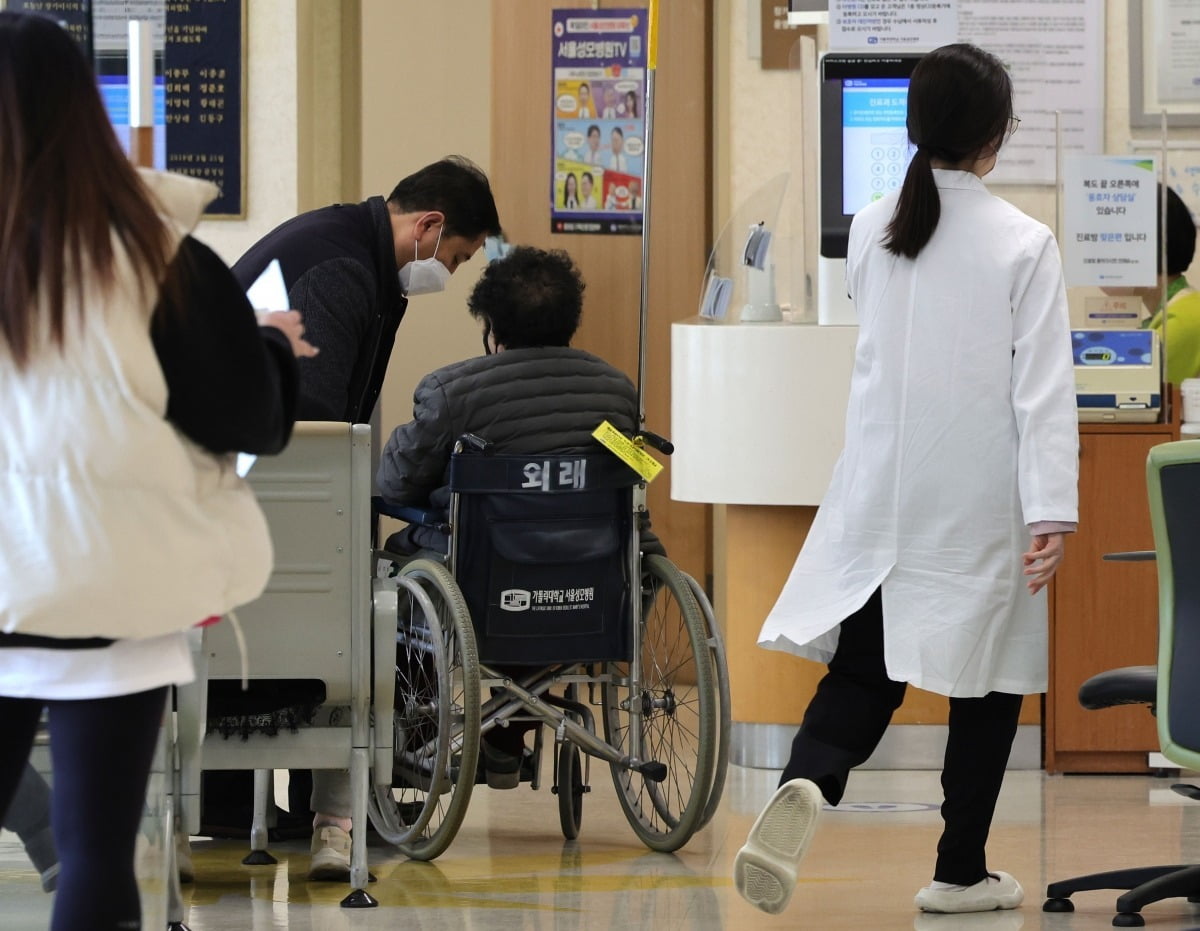22일 서울 시내 한 대학병원에서 한 의료진이 환자 옆을 지나가고 있다./임대철 기자