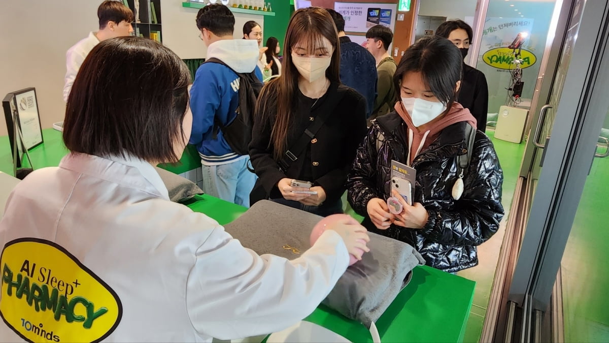 소비자들이 서울 성수동 AI 모션필로우 팝업스토어를 방문해 숙면을 돕는 베개의 기능에 대해 설명을 듣고 있다./제공=텐마인즈