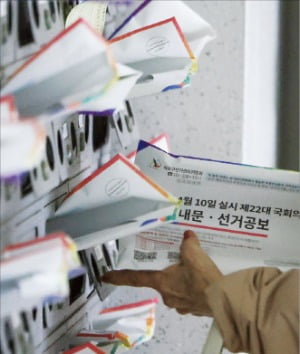 4·10 총선을 열흘 앞둔 31일 서울 마포구의 한 아파트 주민이 우편함에 꽂혀 있는 선거 공보물을 가져가고 있다.  연합뉴스 