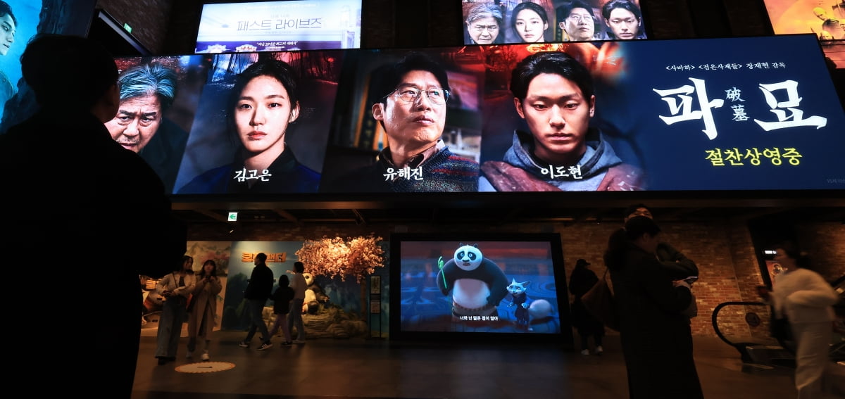 서울의 한 영화관에 ‘파묘’ 홍보물 앞으로 시민들이 지나가고 있는 모습.사진=한경DB