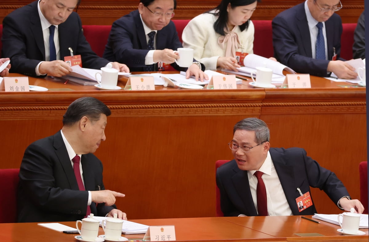 시진핑(왼쪽) 중국 국가주석이 전국인민대표대회에서 리창 총리와 대화하고 있다./연합뉴스