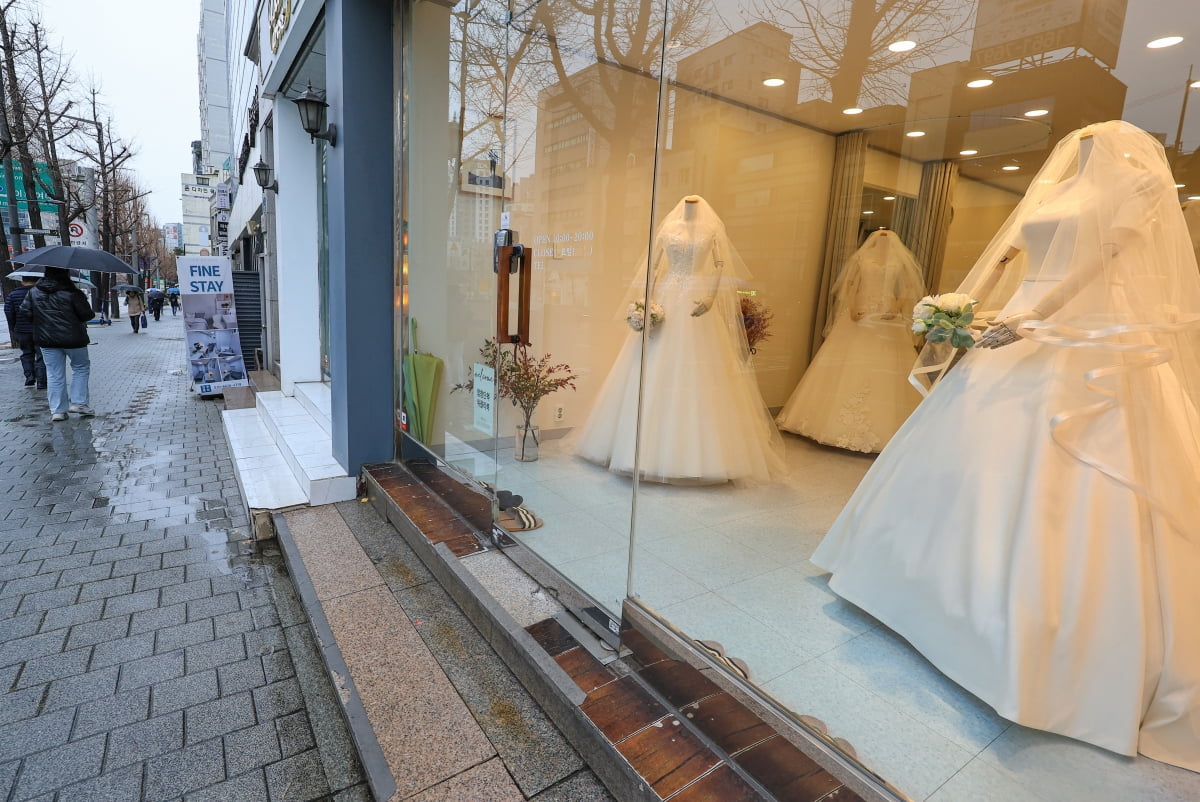 마포구 아현동 웨딩거리 한 웨딩드레스 판매점 앞을 시민들이 지나가고 있다. 사진=연합뉴스