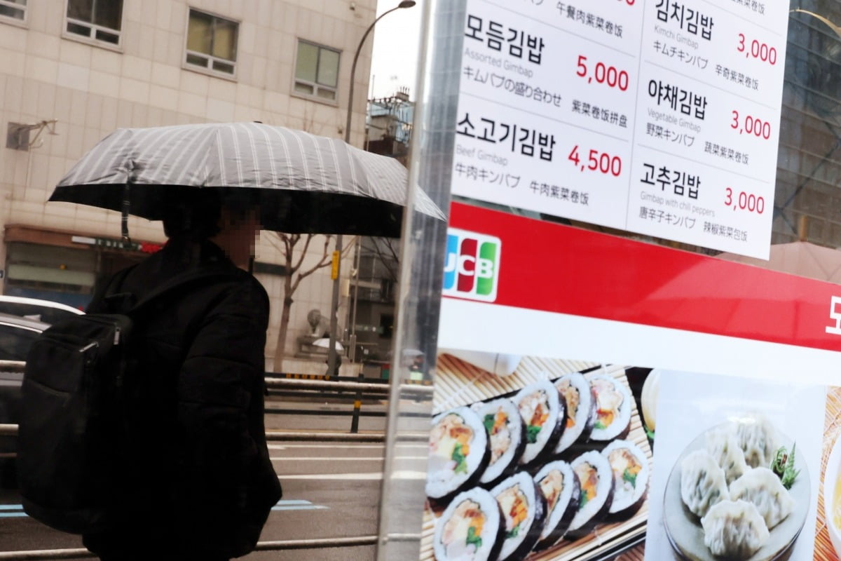 한 시민이 김밥 가격이 표시된 서울 중구의 한 김밥전문점 앞을 지나가고 있다. 사진=연합뉴스