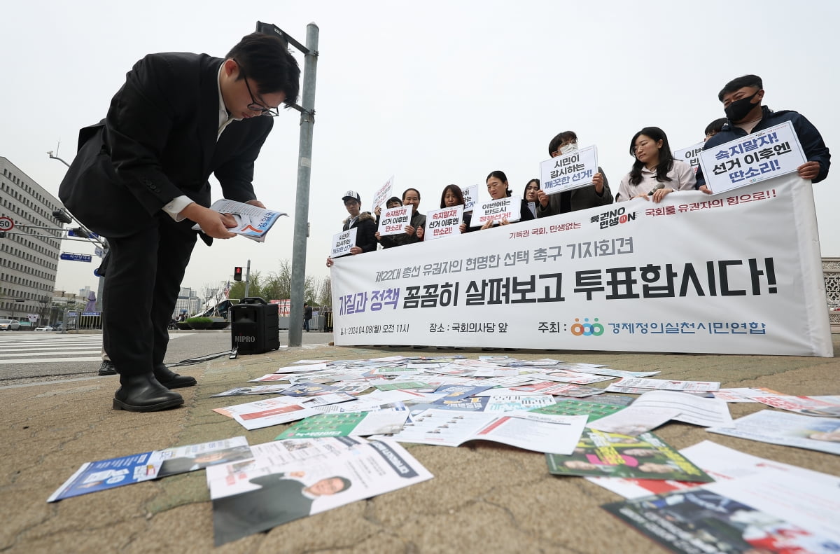 경실련이 8일 오전 서울 영등포구 국회 앞에서 연 '22대 총선 유권자의 현명한 선택 촉구 기자회견' 참가자들이 선거 공보물을 살펴보는 퍼포먼스를 하고 있다=연합뉴스
